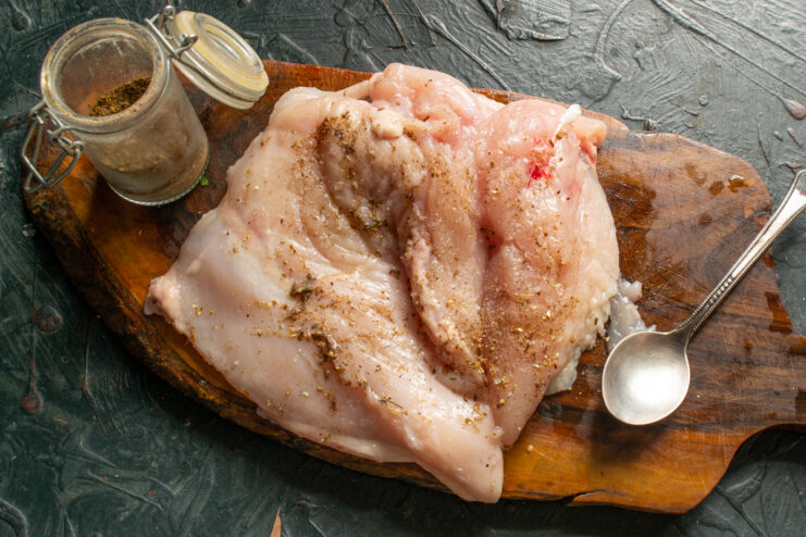 Raw chicken fillet sprinkled with salt and black pepper