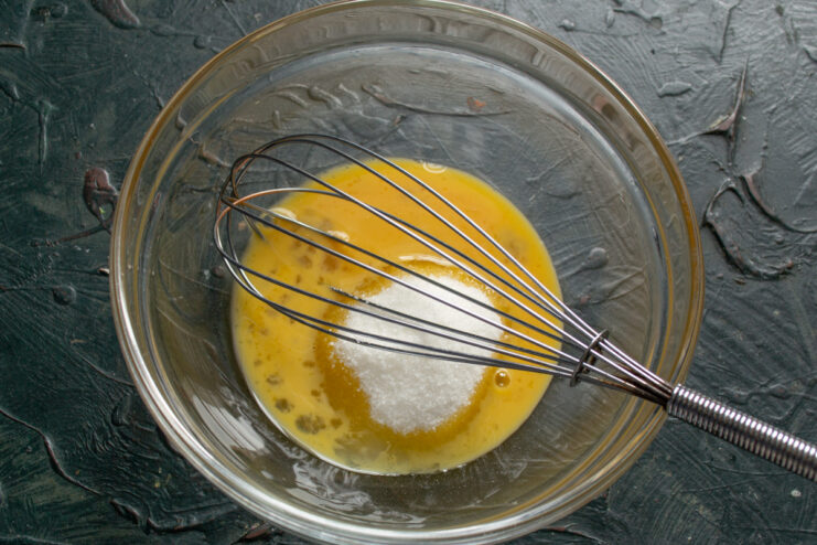 Mixing Egg and Sugar Whisking a fresh egg and granulated sugar into a light foam in a bowl