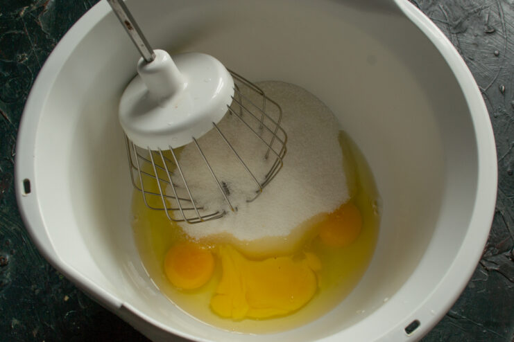 Preparing eggs and sugar Eggs and granulated sugar in a white mixing bowl