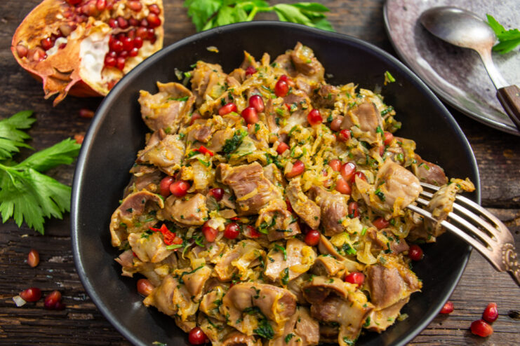 Georgian-style chicken gizzards garnished with pomegranate seeds and cilantro