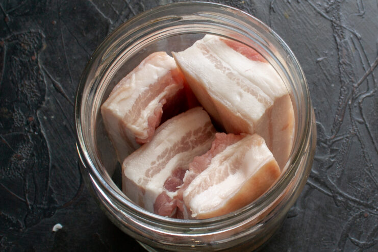 Packing salo into a jar Pieces of raw salo packed tightly into a glass jar