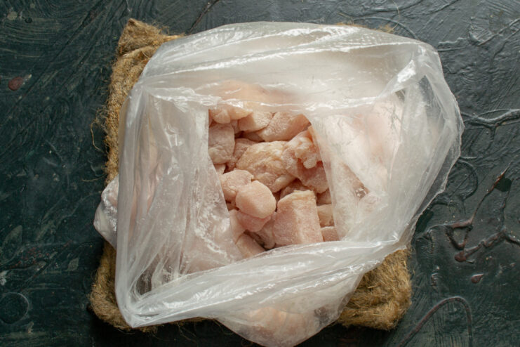 Coating the chicken Diced chicken pieces tossed in flour inside a plastic bag
