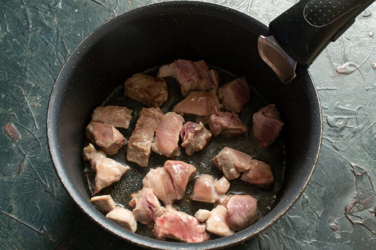 Browning Meat Searing meat pieces in a pot