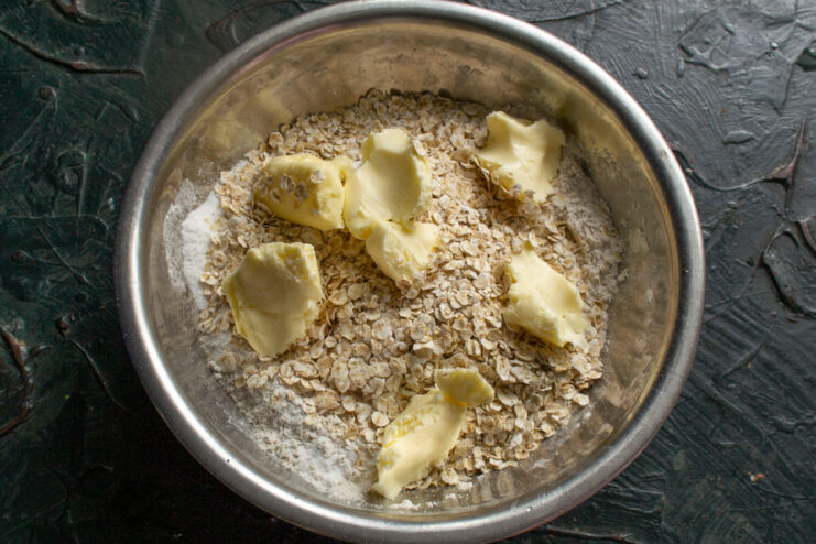 Adding butter Small cubes of softened butter resting in the dry ingredients