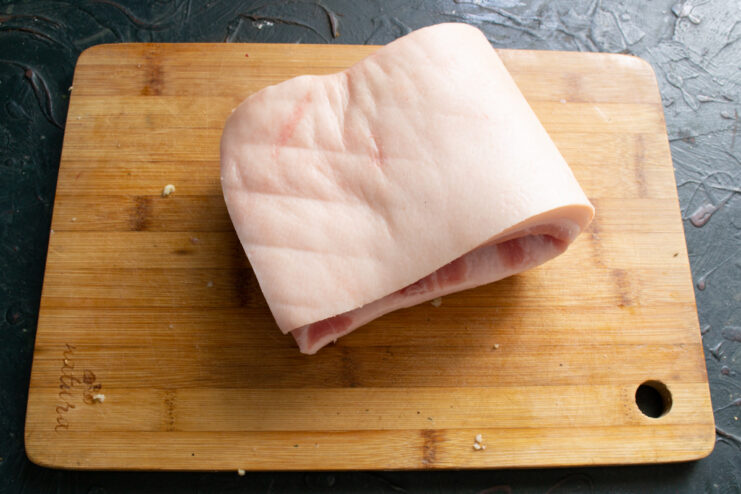 Prepping the skin A thick piece of raw pork fat placed skin-side up on a wooden board