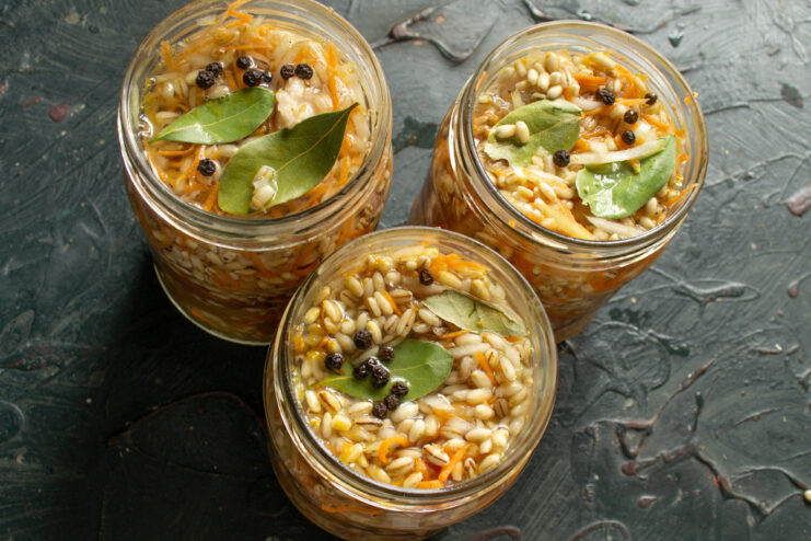 Adding aromatics Bay leaves and whole black peppercorns placed inside glass jars