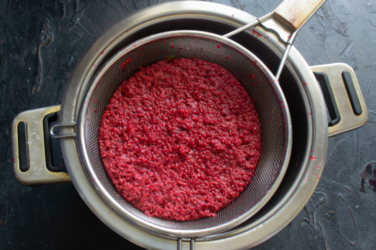 Straining the raspberry puree Raspberry puree in a sieve over a pot