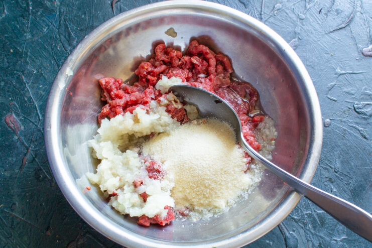 Adding Semolina Semolina being sprinkled into the bowl with ground meat