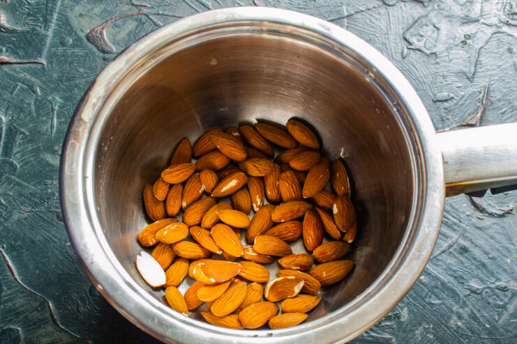 Almonds soaking in a pot of hot water to loosen their skins