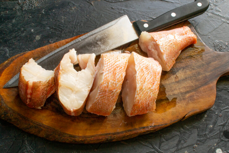 Portioning the Fish Ocean perch cut into large thick chunks on a cutting board