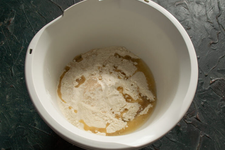 Starting the dough mixture Flour mixed with dry yeast and olive oil in a glass bowl