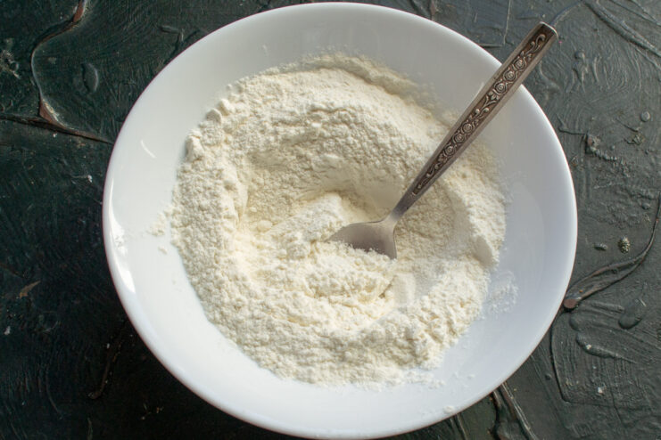 Dry ingredients for cookies All-purpose flour and baking powder mixed in a white bowl
