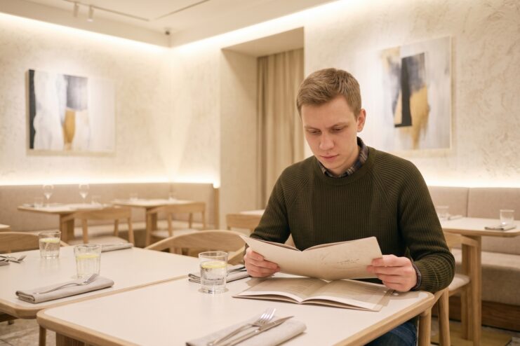 Choosing a dish from a restaurant menu during anxiety A man reviews a menu in a restaurant to choose a safe and manageable dish.