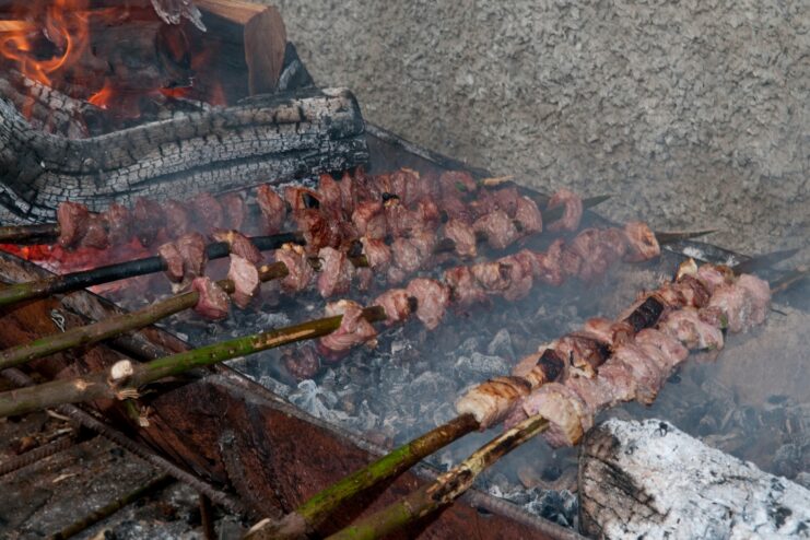 Chunks of beef roasting on traditional bay laurel skewers over hot coals