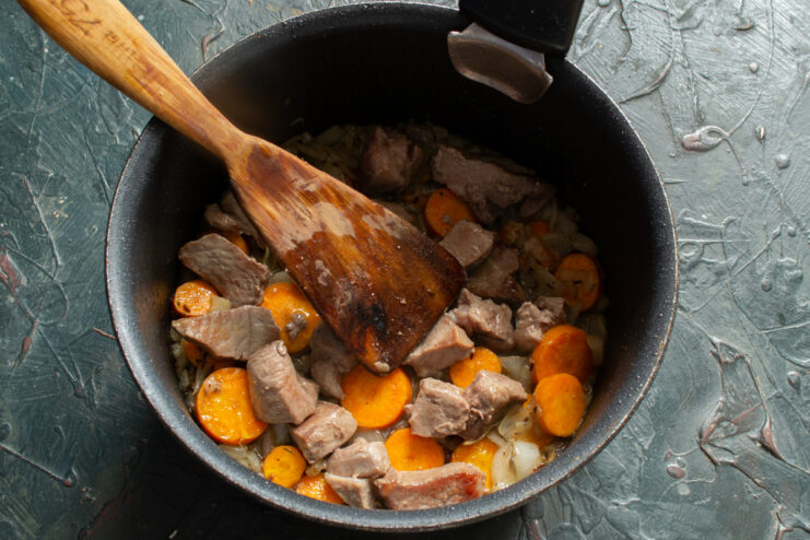 Meat With Vegetables Mixing meat with vegetables in a pot