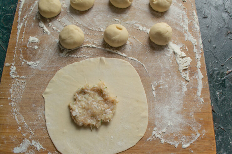 Generous dollop of chicken filling on a thin round dough wrapper