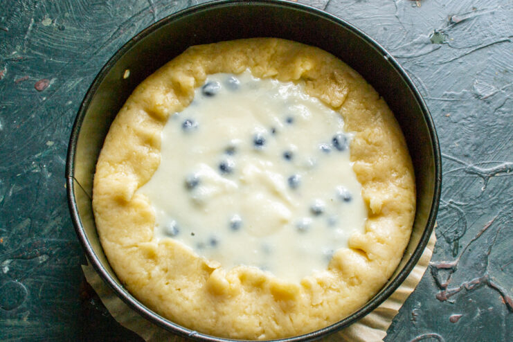 Filling the pie crust and folding the edges Blueberry filling in a dough crust with folded edges