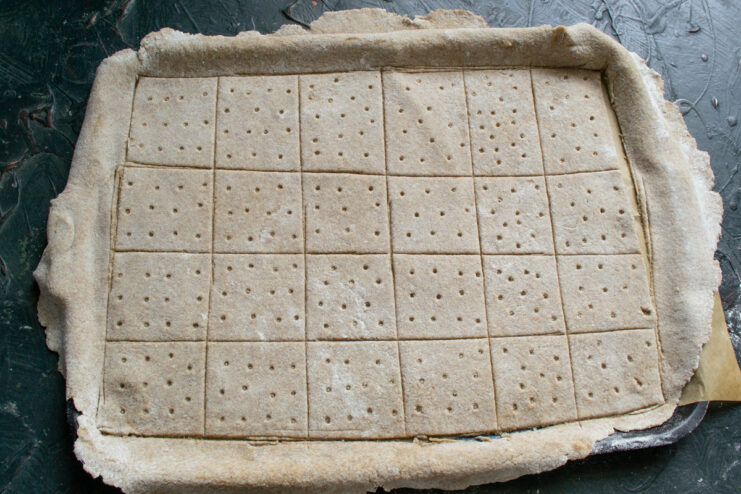 Docking the dough Poking holes in raw rolled dough with a cocktail straw