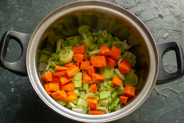 Adding the carrots Diced carrots added to the chopped leeks in a pot