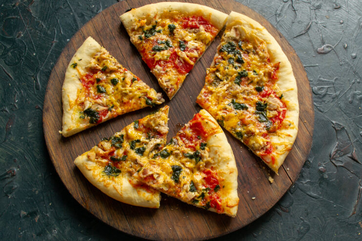 Serving the pizza Sliced hot pizza on a wooden cutting board