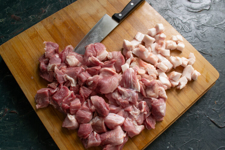 Prepping the meat and fat Diced meat and fat on a wooden cutting board