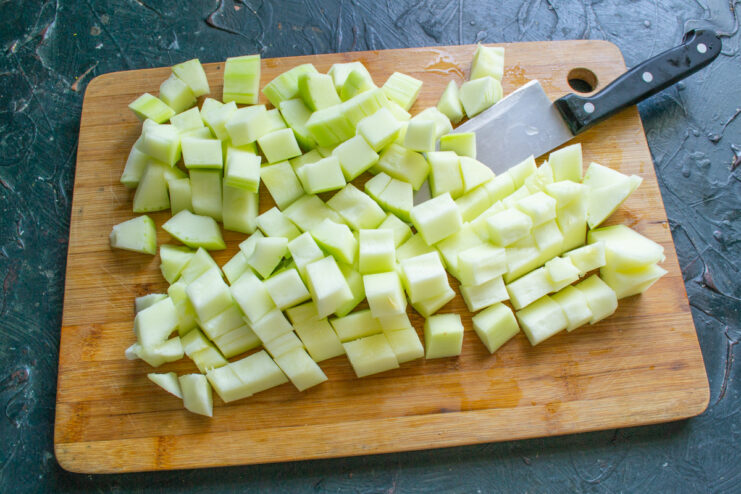 Diced peeled zucchini on a cutting board