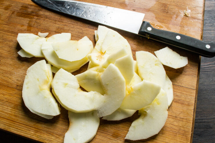 Slicing peeled apples Thinly sliced peeled apples arranged on a wooden cutting board