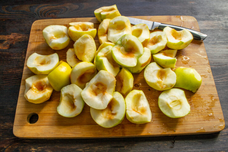 Prepping the Apples Chopped and cored apples with skin on a wooden cutting board