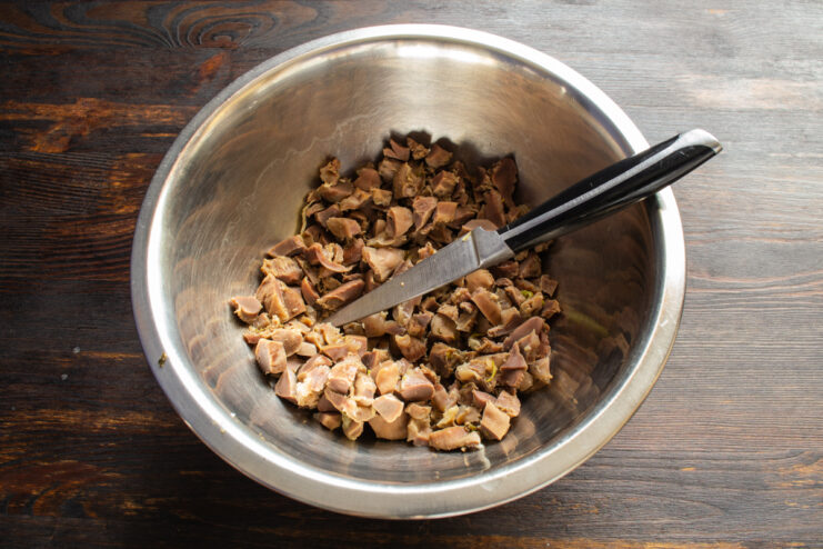Dicing the Giblets Finely diced boiled chicken gizzards in a deep mixing bowl