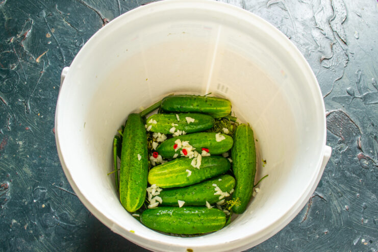 Chopped garlic and sliced hot chili peppers on top of cucumbers