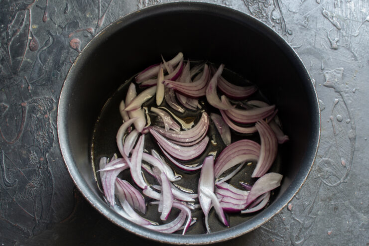 Sautéing the onions Sliced red shallots sautéing in oil in a frying pan