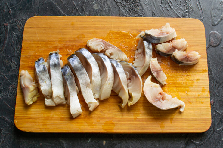 Slicing The Mackerel Fillet Slicing lightly salted mackerel fillets on a wooden board