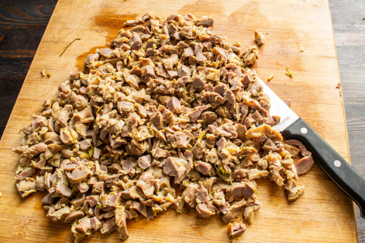 Chopping the gizzards Finely chopping cooked chicken gizzards with a knife