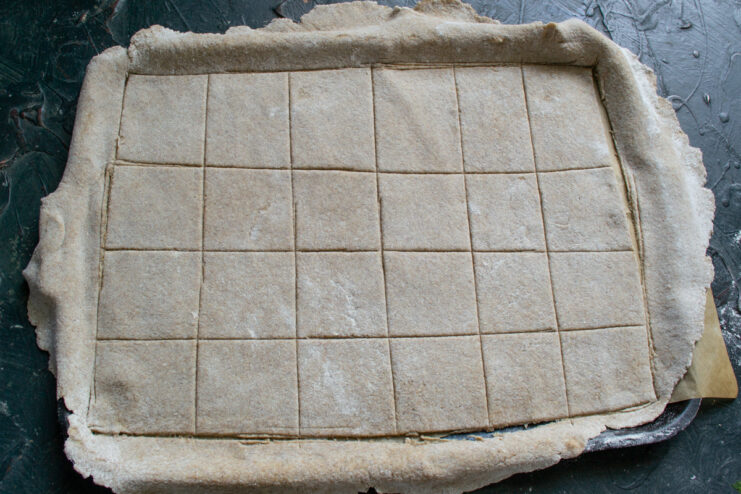 Scoring the crackers Scoring dough into rectangular portions using a bench scraper