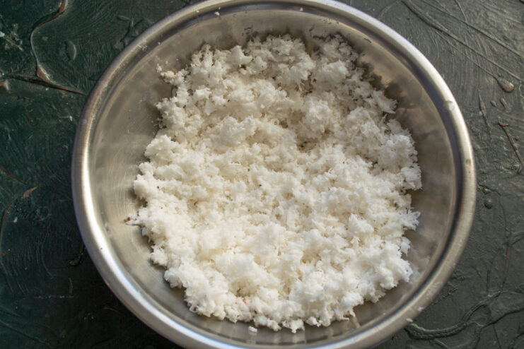 Freshly grated coconut Finely grated fresh coconut meat in a glass bowl