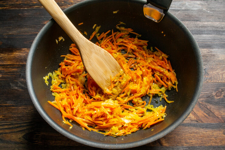 Vegetable base Sauteed julienned carrots and onions in a wide pan
