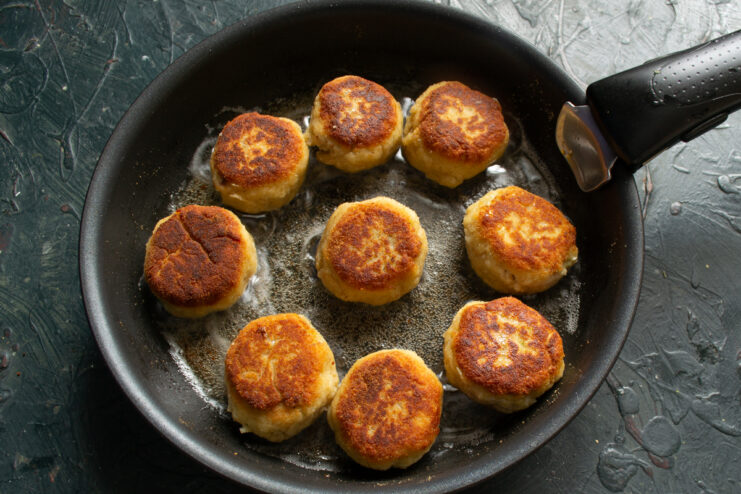 Frying Until Golden Brown Fishballs pan-fried to a golden brown crust in a skillet.