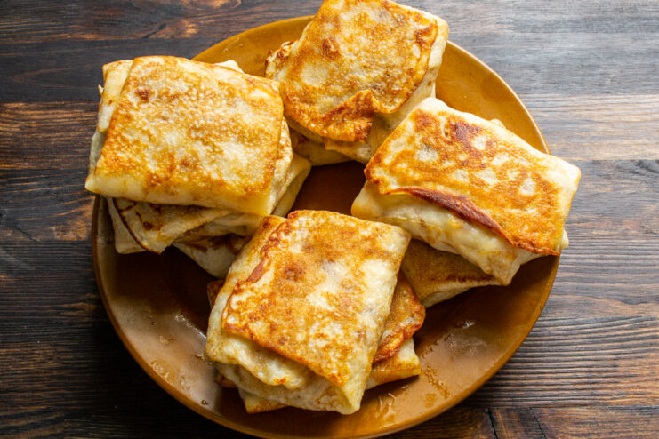 Pan-frying before serving Pan-fried stuffed crepes with a golden crust on a plate