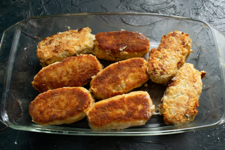 Preparing for Baking Pan-fried golden fish patties placed in a baking dish