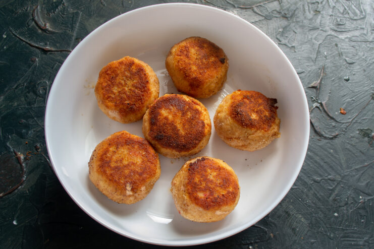 Browned fish meatballs placed in a deep baking dish