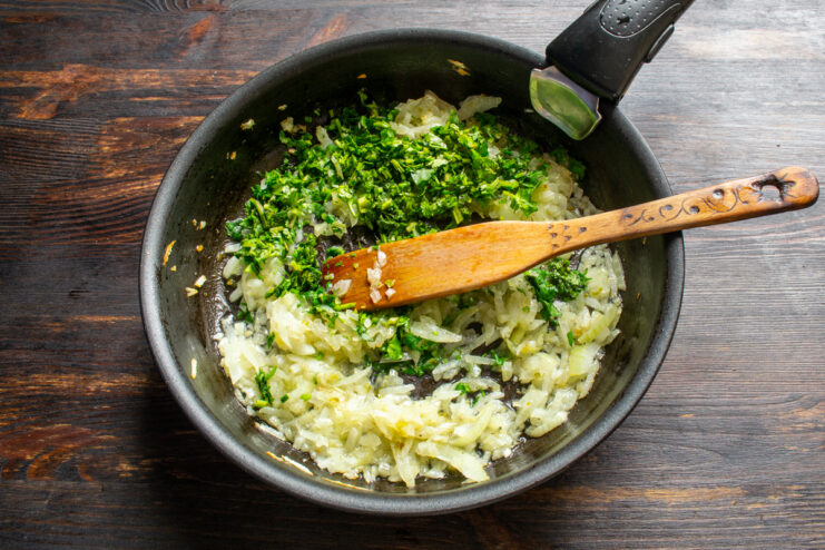 Sauteing onion and cilantro Sauteed onions mixed with fresh green cilantro in a skillet
