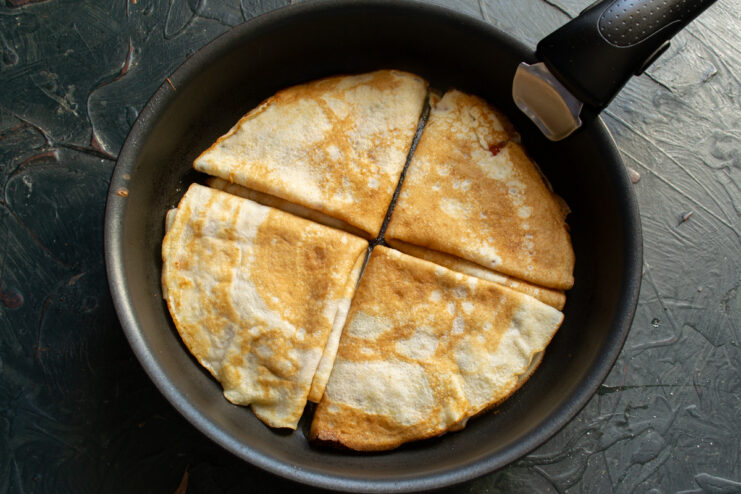 Pan-frying folded triangular crepes in a skillet