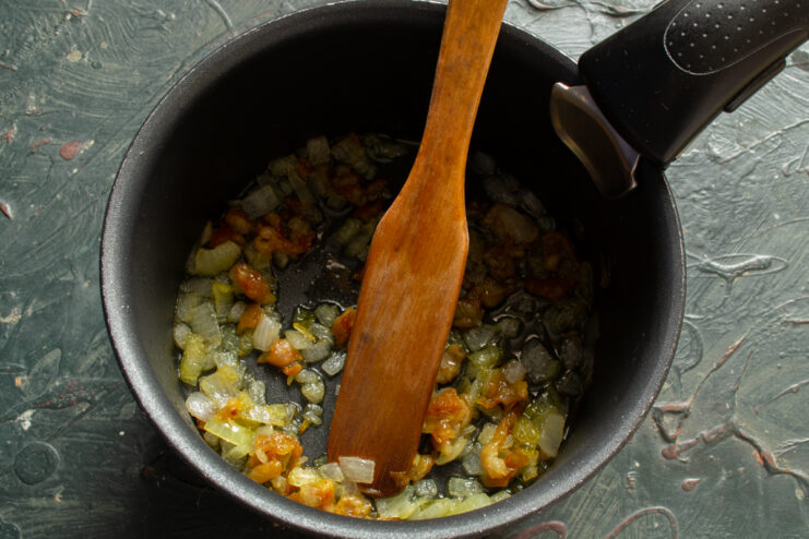 Golden Chicken Cracklings Frying crispy chicken cracklings and chopped onions in a pan
