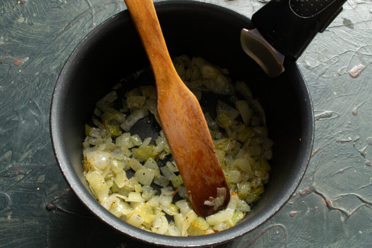 Sautéing the onions Sautéing finely chopped onions in a pot to build the flavor base for the soup.