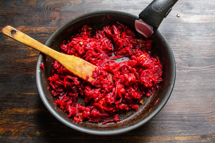 Preparing the beet base Sautéing grated beets, apples, and diced tomatoes in a skillet