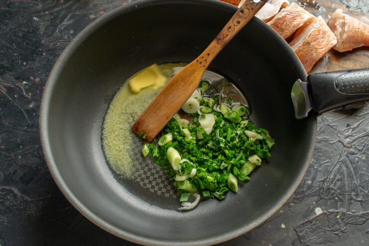 Sautéing Herbs and Garlic Chopped green onions and parsley cooking in melted butter