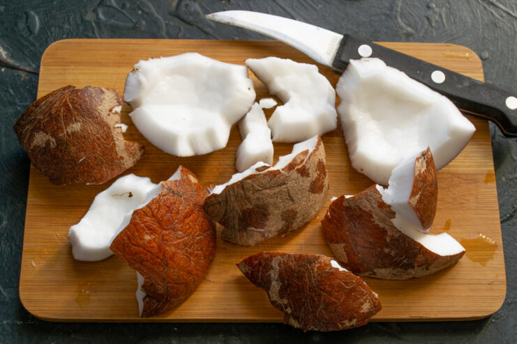 Preparing fresh coconut Peeled fresh coconut meat resting on a wooden cutting board