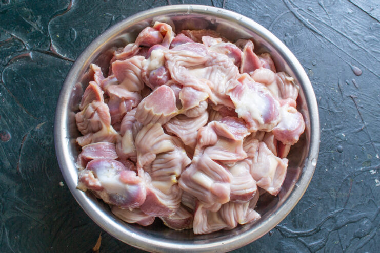 Prepping the chicken gizzards Cleaned raw chicken gizzards in a bowl