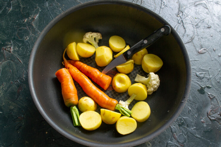 Vegetables for the fish soup Peeled new potatoes, whole baby carrots, and cauliflower florets inside a cooking pot