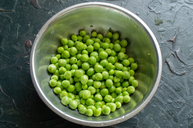 Freshly shelled green peas in a bowl ready for canning